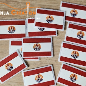 Könnte beinhalten: Nahaufnahme von mehreren gestickten Aufnähern mit der Flagge Französisch-Polynesiens. Die Aufnäher sind weiß mit rotem Hintergrund und einem stilisierten Bild eines Schiffsrades mit einer aufgehenden Sonne dahinter.