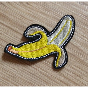 May include: An embroidered yellow banana patch with a white peel and black stitching.