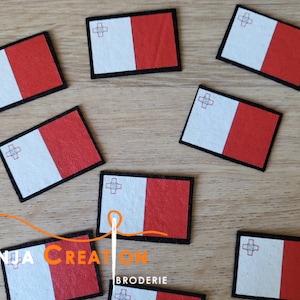 May include: Eight small, rectangular, felt patches featuring the flag of Malta. The flag is white with a red cross and a red stripe on the right side. The patches are surrounded by a black border.