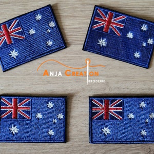 May include: Four embroidered Australian flag patches with a blue background, red and white Union Jack in the top left corner, and white stars in the field. The patches are on a wooden surface.