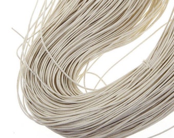 May include: A close-up of a spool of natural white twine. The twine is tightly wound and appears to be made of a natural fiber.