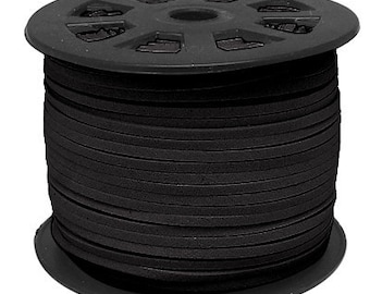 Puede incluir: Un carrete de cordón de cuero negro, enrollado firmemente en un carrete de plástico negro con un agujero central.