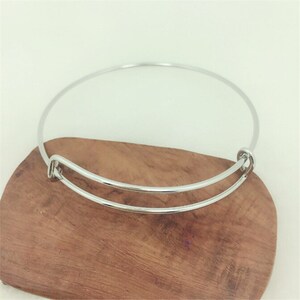 May include: A silver bangle bracelet with a spring clasp.