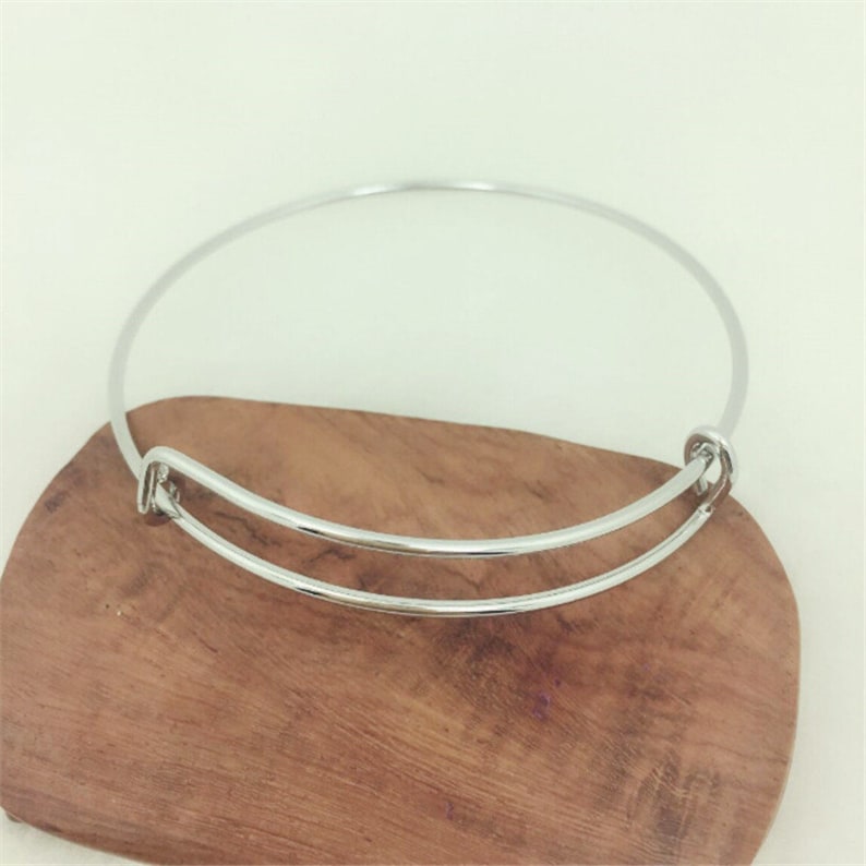 May include: A silver bangle bracelet with a spring clasp.