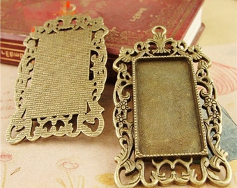 May include: Two antique gold-toned metal frames with ornate designs. The frames are rectangular and have a bevelled edge. They are perfect for adding a vintage touch to your jewellery making projects.
