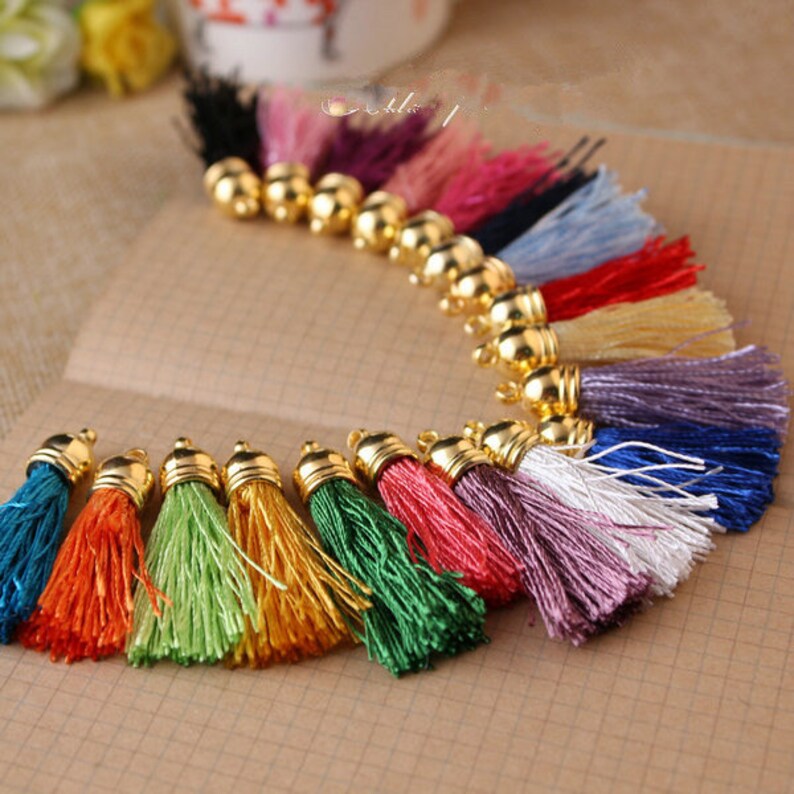 May include: Assortment of colorful tassel trims with gold metal caps. The tassels are made of soft, silky threads and are perfect for adding a touch of elegance to crafts, clothing, and home decor projects.