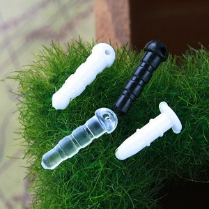 May include: Four phone jack dust covers, two white, one clear, and one black. The covers are on a green surface.