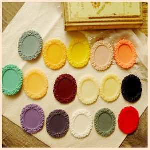 May include: Assortment of 15 oval-shaped, decorative, blank, cameo-style, resin, picture frames in various colors, including red, green, purple, yellow, orange, white, black, and brown.