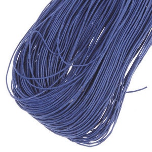 May include: A close-up of a bundle of blue waxed cotton cord. The cord is tightly wound and has a smooth, polished finish.