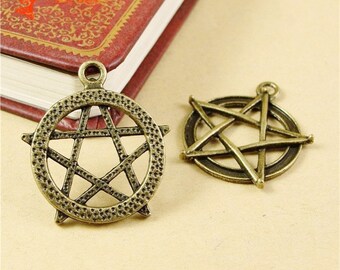 May include: Two antique bronze-colored pentagram pendants. One pendant features a pentagram within a dotted circle, while the other has a simpler pentagram design. Both have a loop for hanging. The pendants are likely for jewelry or craft projects.