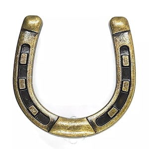 May include: A gold-colored horseshoe with black accents. The horseshoe has a traditional shape with a rounded top and a flat bottom.