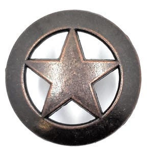 May include: A bronze-colored metal star-shaped button with a circular border. The star is in the center of the button and has five points. The button has a rustic, weathered appearance.