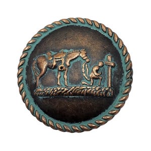 May include: A round, bronze-colored metal button with a turquoise rope-like border. The button features a detailed relief of a saddled horse, a kneeling figure, and a cross. The design has a rustic, aged appearance.