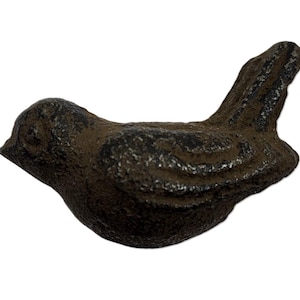 May include: A cast iron bird figurine in a dark, weathered finish. The bird is depicted in a resting pose, with detailed feather textures. The figurine is designed for decorative purposes.