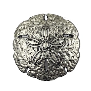May include: A silver-colored sand dollar pendant with a textured surface and a five-petal design in the center. The pendant has three small holes and a larger hole at the bottom. The sand dollar is a popular beach-themed item.