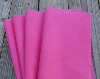 May include: A stack of four pink tissue paper sheets.