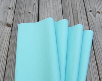 May include: Five sheets of light blue felt fabric stacked on top of each other. The felt is smooth and has a soft texture.
