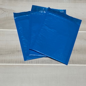 May include: Three blue padded mailing envelopes stacked on top of each other.