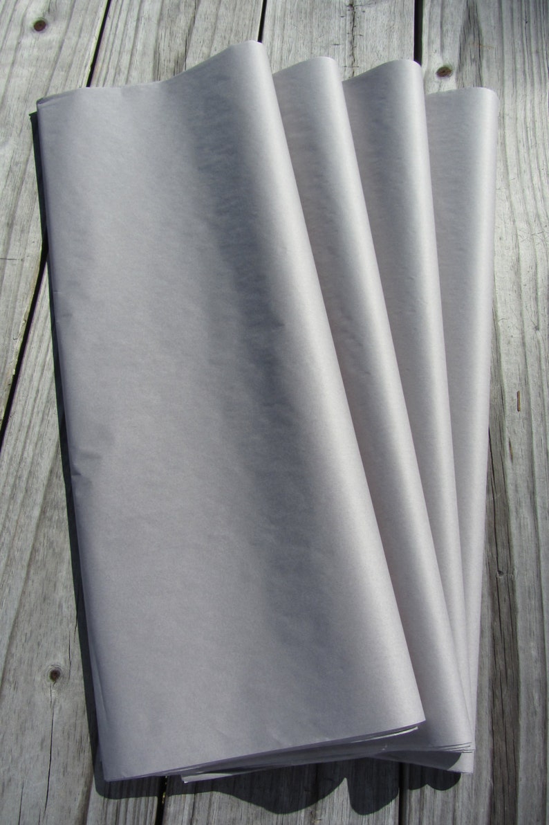 May include: A stack of four sheets of light gray tissue paper. The paper is smooth and has a slight sheen.