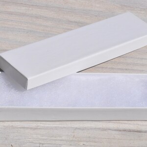 May include: A white cardboard box with a white foam insert. The box is open and the foam insert is visible.