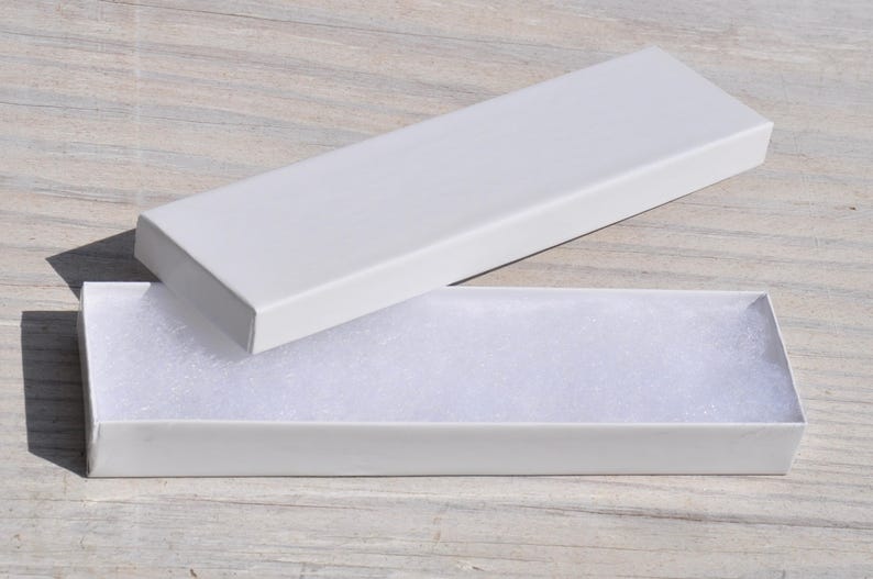 May include: A white cardboard box with a white foam insert. The box is open and the foam insert is visible.