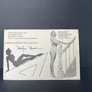 May include: A vintage print featuring Marilyn Monroe. The black and white image includes a silhouette of Monroe, her signature, and text that reads "A New Concept in Curves." The print also features a photo of Monroe posing on a staircase.