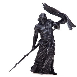 May include: A silver-colored statue of Zeus, the Greek god of the sky and thunder, holding a staff and an eagle in his right hand.