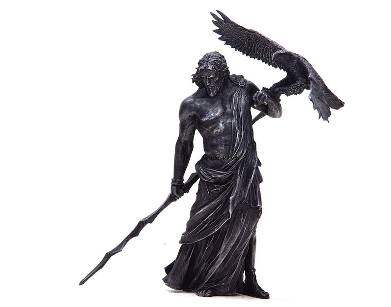May include: A silver-colored statue of Zeus, the Greek god of the sky and thunder, holding a staff and an eagle in his right hand.