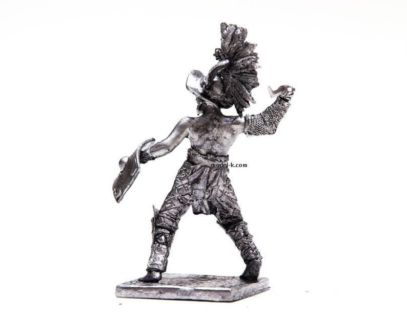 K&ouml;nnte beinhalten: Eine silberne Metallfigur eines Gladiators, der ein Schwert und einen Schild h&auml;lt. Der Gladiator tr&auml;gt einen Helm und eine R&uuml;stung. Die Figur steht auf einem kleinen Sockel.