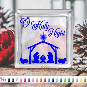 May include: A clear glass block with a blue vinyl decal of a nativity scene and the text "O Holy Night".