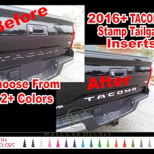 May include: Before and after images of a black Toyota Tacoma pickup truck. The before image shows the stock tailgate with the word "TACOMA" embossed. The after image shows the tailgate with custom inserts that make the word "TACOMA" stand out in white. The text "2016+ TACOMA Stamp Tailgate Inserts" is displayed above the images. Below the images, the text "Choose From 12+ Colors" is displayed. A row of 17 different colored unicorn horn decals is displayed below the text.