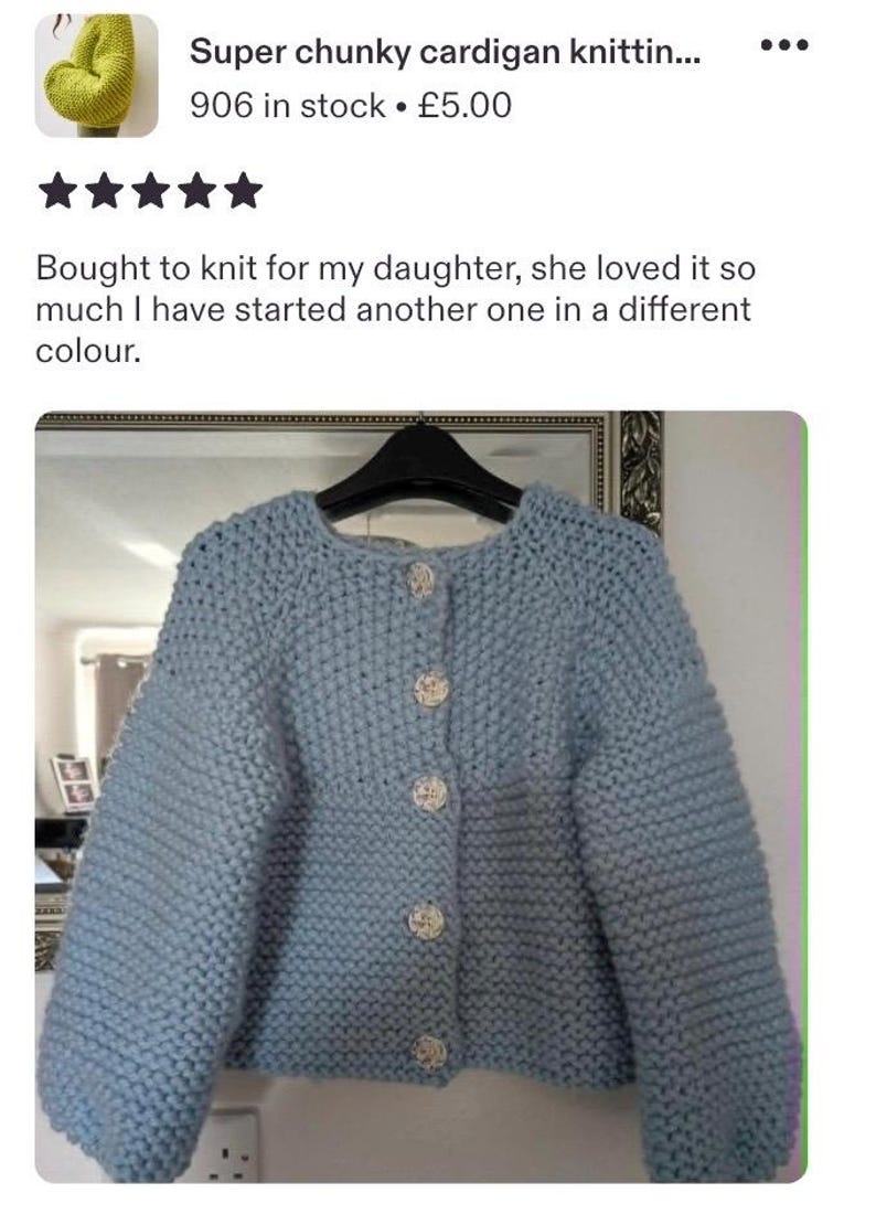 May include: A light blue chunky knit cardigan featuring a round neckline, long sleeves, and five round, textured white buttons down the front. The garment is displayed on a black hanger, showcasing a thick, textured yarn construction throughout.