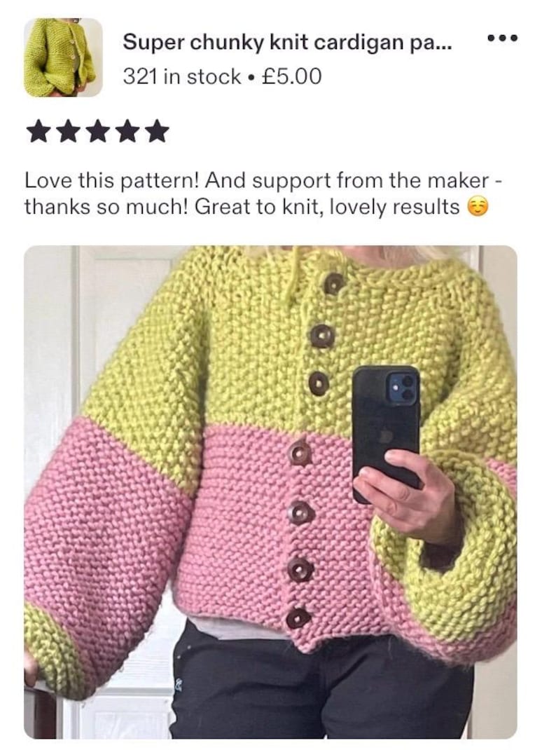 May include: A chunky knit cardigan featuring a color-blocked design with a lime green upper section and a pink lower section. The garment has long, voluminous sleeves, a round neckline, and a front button closure with six dark brown buttons.