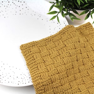 May include: A mustard yellow knitted dishcloth with a textured weave pattern.