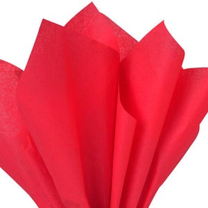 May include: Red tissue paper, crumpled and folded, with a soft, crinkled texture. The paper is a vibrant, bright red color.