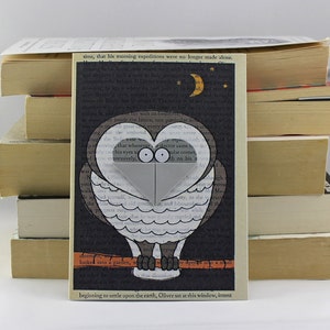 May include: A black and white owl bookmark with a heart-shaped cutout in the middle. The owl is perched on a branch with a small moon and stars in the background. The text "time, that his morning expeditions were no longer made alone." is printed on the bookmark.