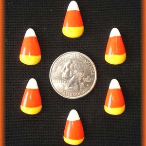 May include: A collection of candy corn candies arranged around a quarter coin on a black background. The candies are white, orange, and yellow. The coin is silver and has the words "Quarter Dollar" and "In God We Trust" on it.