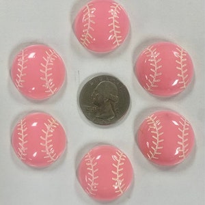 May include: Six pink baseball-themed buttons with white stitching. The buttons are approximately the size of a US quarter.