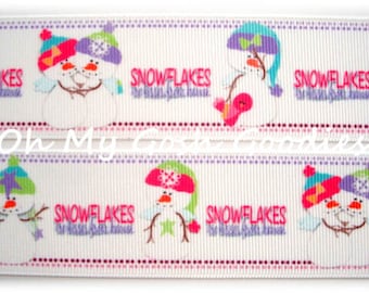 May include: White ribbon with a repeating pattern of snowmen wearing hats and scarves. The ribbon has the text "Snowflakes" repeated on it.