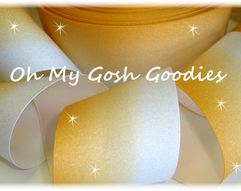 May include: A roll of gold and white ombre glitter ribbon. The ribbon is 2.5 inches wide and has a subtle shimmer.