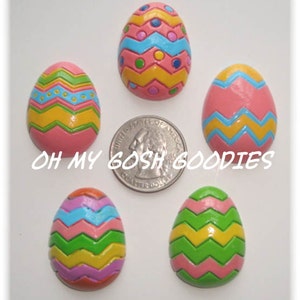 以下が含まれることがあります： シマ模様のカラフルなイースターエッグが5つ。卵はピンク、イエロー、グリーン、ブルー、パープル。卵は白い水玉模様で飾られています。