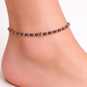 Puede incluir: Una taza de cerámica blanca con asa negra y el texto "But First, Coffee" en negrita negra. La taza se encuentra sobre un fondo borroso, sugiriendo un ambiente acogedor.