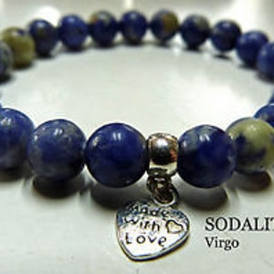 May include: A blue sodalite gemstone bracelet with a silver heart charm that says "Made with love". The bracelet is labeled "Sodalite Virgo".