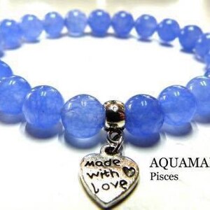 May include: A light blue aquamarine gemstone bracelet with a silver heart charm that says "Made with Love". The bracelet is labeled "Aquamarine Pisces".