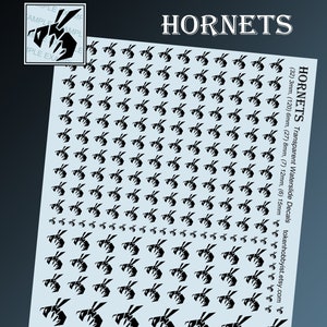 Op de afbeelding: Een vel met transparante waterslide-decals met zwarte wesp-silhouetten in verschillende maten. Het vel bevat 32 decals van 3 mm, 120 decals van 6 mm, 27 decals van 8 mm, 7 decals van 12 mm en 6 decals van 15 mm. Het vel is gelabeld met "HORNETS Transparent Waterslide Decals" en bevat het website-adres "tokenhobbyist.etsy.com".
