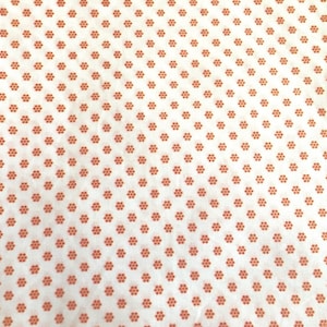 May include: White fabric with a repeating pattern of small orange flowers.