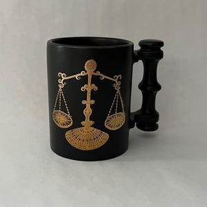 May include: A set of three ceramic mugs with a speckled, matte finish. The mugs are in shades of cream, light gray, and dark gray. Each mug has a simple, minimalist design, perfect for coffee or tea.