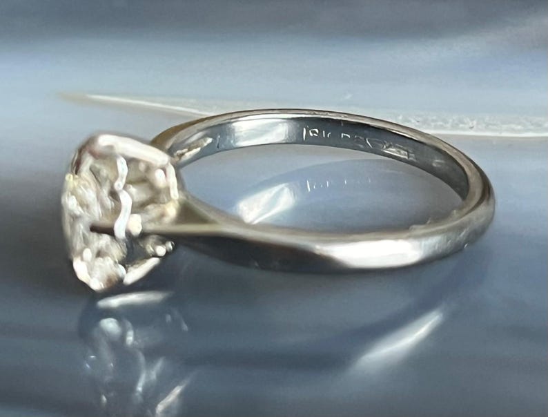 Puede incluir: Un anillo de plata con una banda texturizada y una gran piedra preciosa facetada. El anillo est&aacute; marcado con "14K" en el interior de la banda.