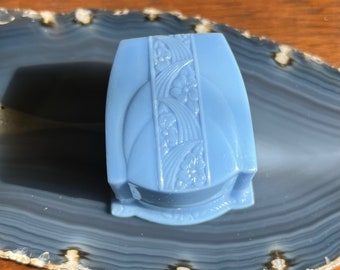 May include: A light blue, decorative box with an embossed floral design. The box is made of glass and has a hinged lid.