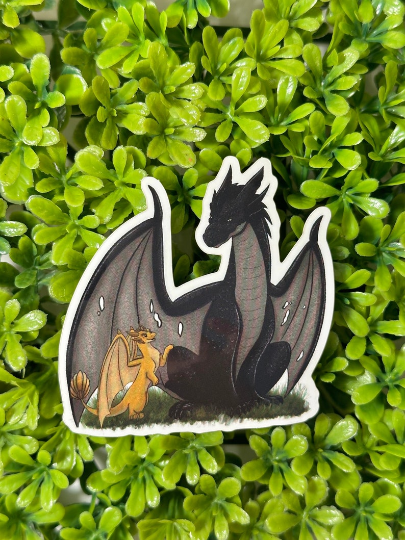 May include: A sticker featuring a black dragon with a gray wingspan and a smaller yellow dragon with a gray wingspan. The dragons are facing each other and appear to be interacting.
